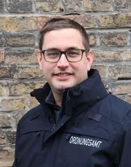 Dominique Geter Das Foto zeigt Dominique Geter in der Uniform eines Hilfspolizisten vor einer Klinkerwand