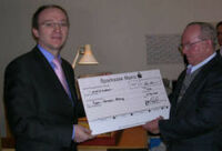 Klemens Diekmann, Vorstandssprecher der Stadtwerke Mainz, überreicht Eugen Schenkel einen Spendenscheck über 12.000 Euro.