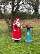 Das Bild zeigt Bademeisterin Elke Sparkuhl im Weihnachtsmann-Kostüm an einem bunten Stehtisch stehend.