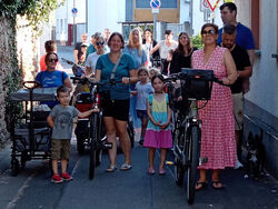 Mit "Sack und Pack" zum Übergangskindergarten. Auf dem Foto sind die Kindergartenkinder nebst Eltern und Erzieherinnen und Erziehern zu sehen, die zu Fuß, durch die Straßen zum Übergangskindergarten laufen.