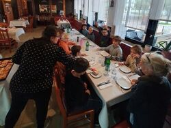 Auf dem Foto sind die Ferienspielkinder und eine Betreuerin beim "Pizza-Essen" in einem Italienischen Restaurant zu sehen.